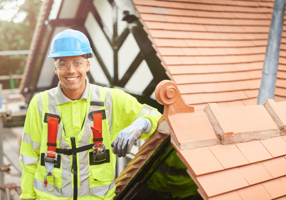 Roofer Leaning On Roof Smiling